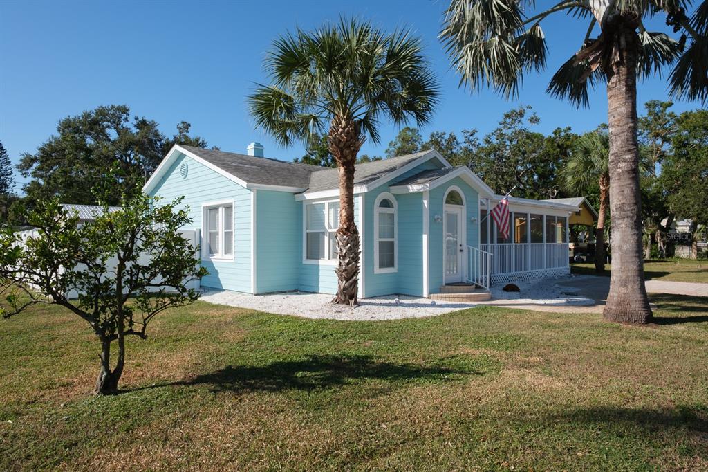 A light blue, single-story house with a screened porch and palm trees in the yard — 5302 28TH AVENUE S, GULFPORT, FL