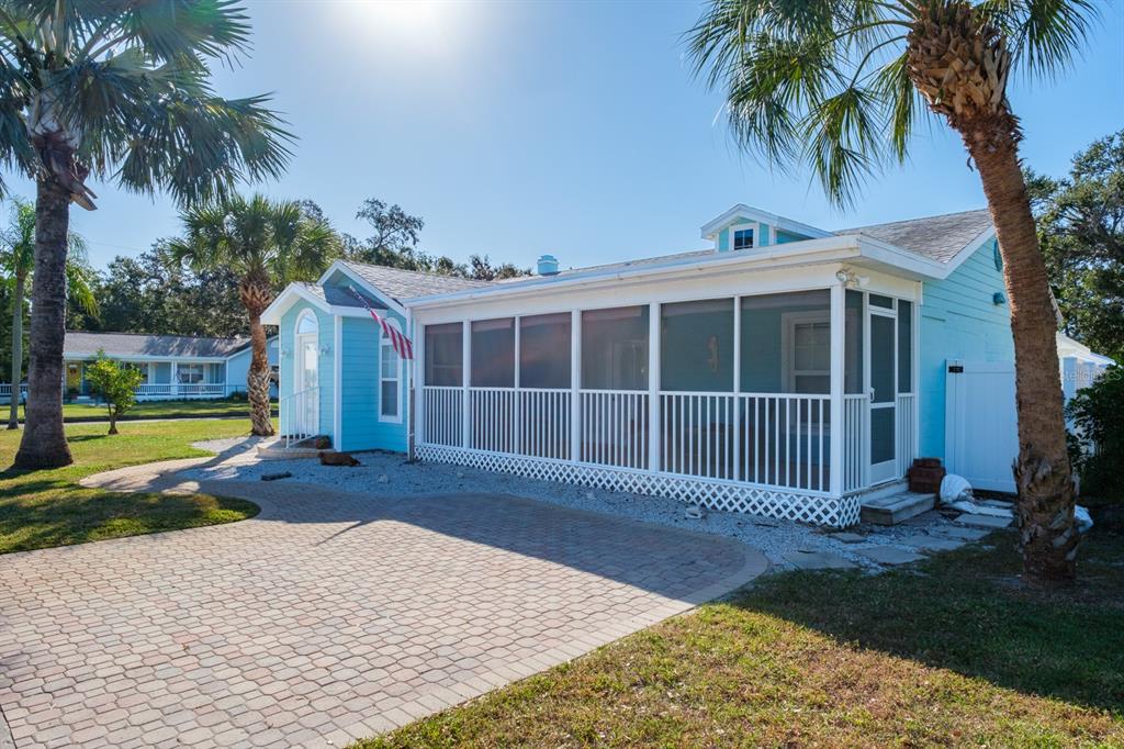 A light blue house with a screened-in porch and a paved driveway under palm trees — 5302 28TH AVENUE S, GULFPORT, FL