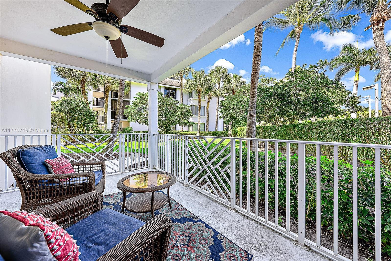 A covered patio features wicker chairs, a small glass table, and a white metal railing — 1015 S Bay Colony Drive S Slip 17, Juno Beach FL 33408, JUNO BEACH, FL