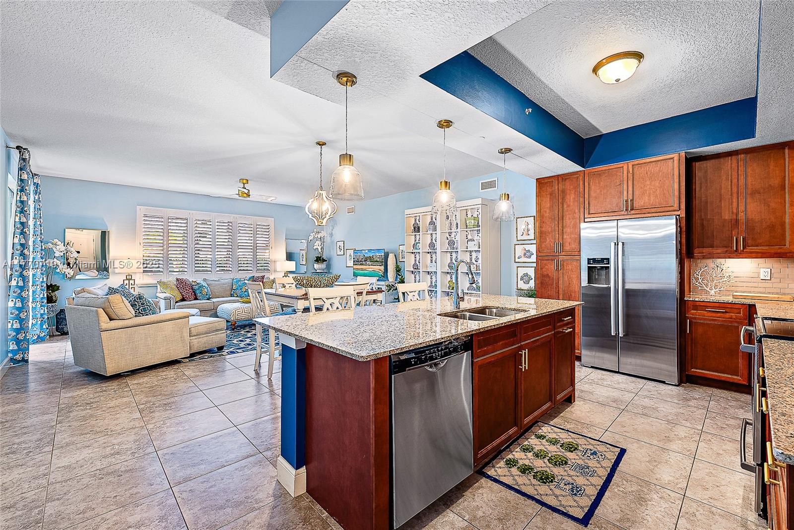 An open-concept kitchen features dark wood cabinets, granite countertops, and stainless steel appliances — 1015 S Bay Colony Drive S Slip 17, Juno Beach FL 33408, JUNO BEACH, FL