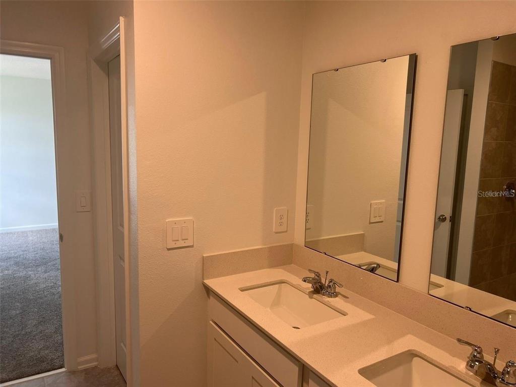 A bathroom features a double vanity with white countertops, two sinks, and two wall mirrors — 1756 WHITE WATER COURT, DAVENPORT, FL