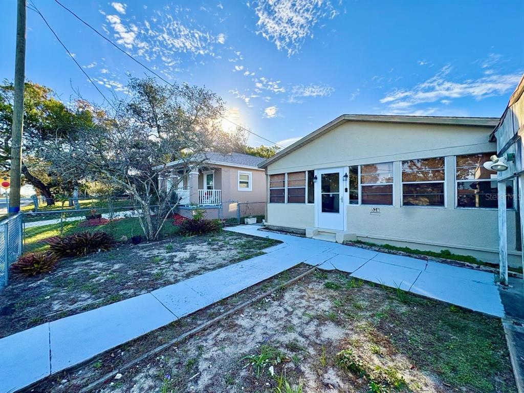 A light-colored house with a front walkway and a neighboring home under a sunny sky — 524 E LIME STREET, TARPON SPRINGS, FL