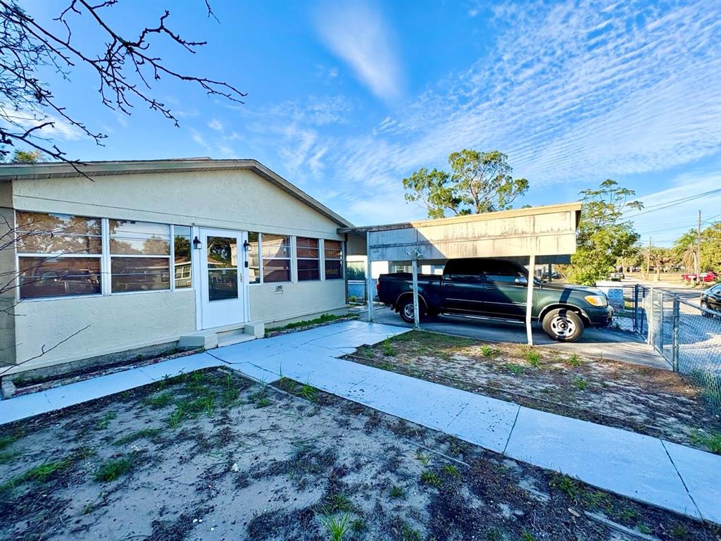 A single-story house with a carport, a dark pickup truck, and a painted concrete walkway — 524 E LIME STREET, TARPON SPRINGS, FL