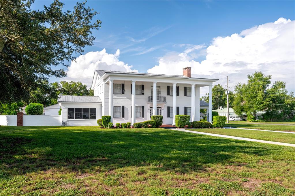 A two-story white colonial-style house features a large front porch with tall columns — 300 3RD STREET NE, FORT MEADE, FL