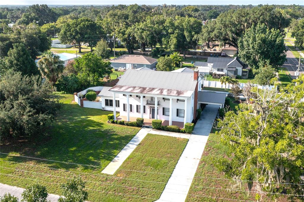 An aerial view of a two-story white house with a metal roof and front columns — 300 3RD STREET NE, FORT MEADE, FL