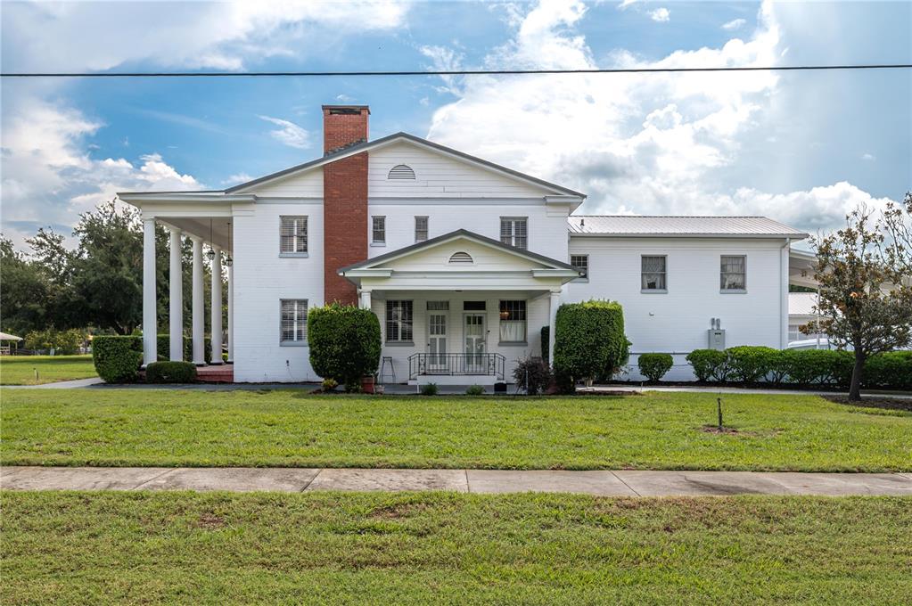 A white two-story house with a brick chimney, a front porch, and columns — 300 3RD STREET NE, FORT MEADE, FL