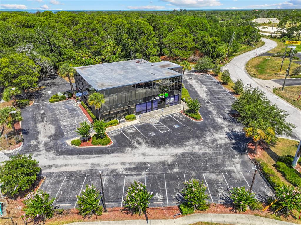 An aerial view shows a two-story commercial office building surrounded by a large parking lot — 9037 S US 19 HIGHWAY S UNIT 9037, PORT RICHEY, FL