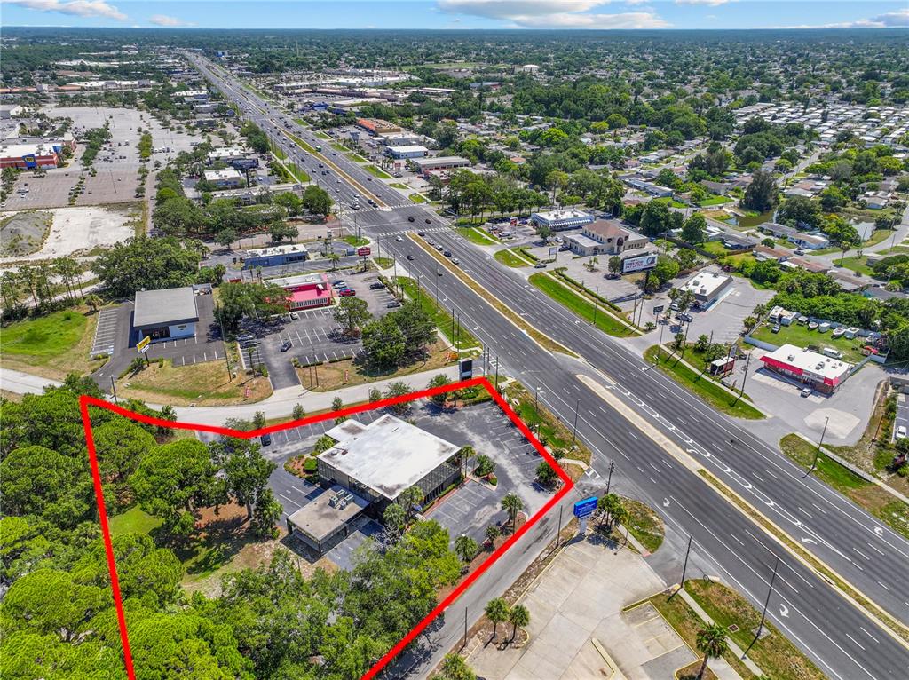 An aerial view shows a commercial building with a parking lot outlined in red — 9037 S US 19 HIGHWAY S UNIT 9037, PORT RICHEY, FL