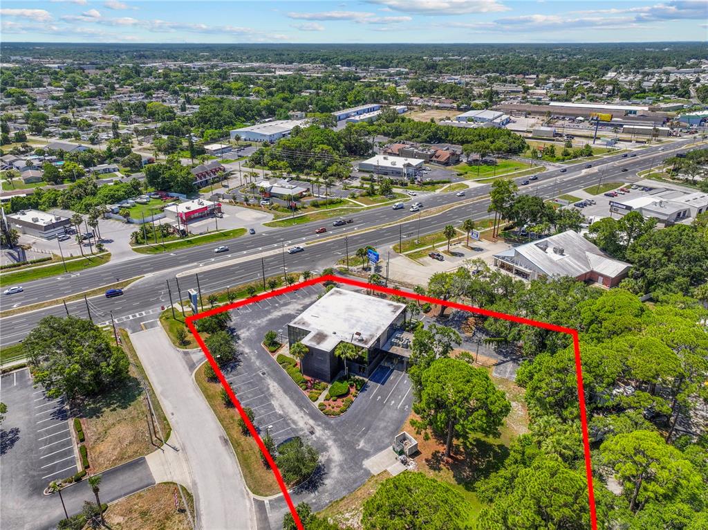 An aerial view shows a commercial building with a parking lot outlined in red — 9037 S US 19 HIGHWAY S UNIT 9037, PORT RICHEY, FL
