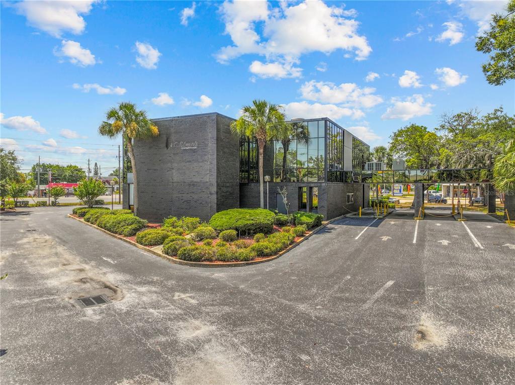 A two-story commercial building with dark brick, glass walls, and a drive-thru lane — 9037 S US 19 HIGHWAY S UNIT 9037, PORT RICHEY, FL