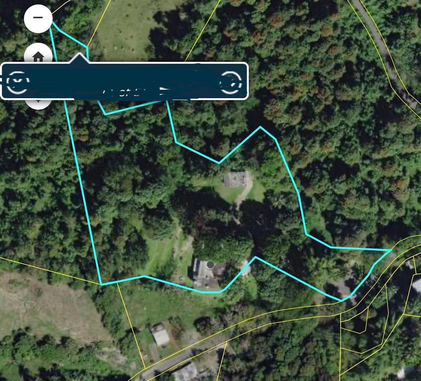 This is an aerial map showing a property boundary outline over a wooded residential lot — 910 CAMINO LAS FLORES, HUMACAO, PR