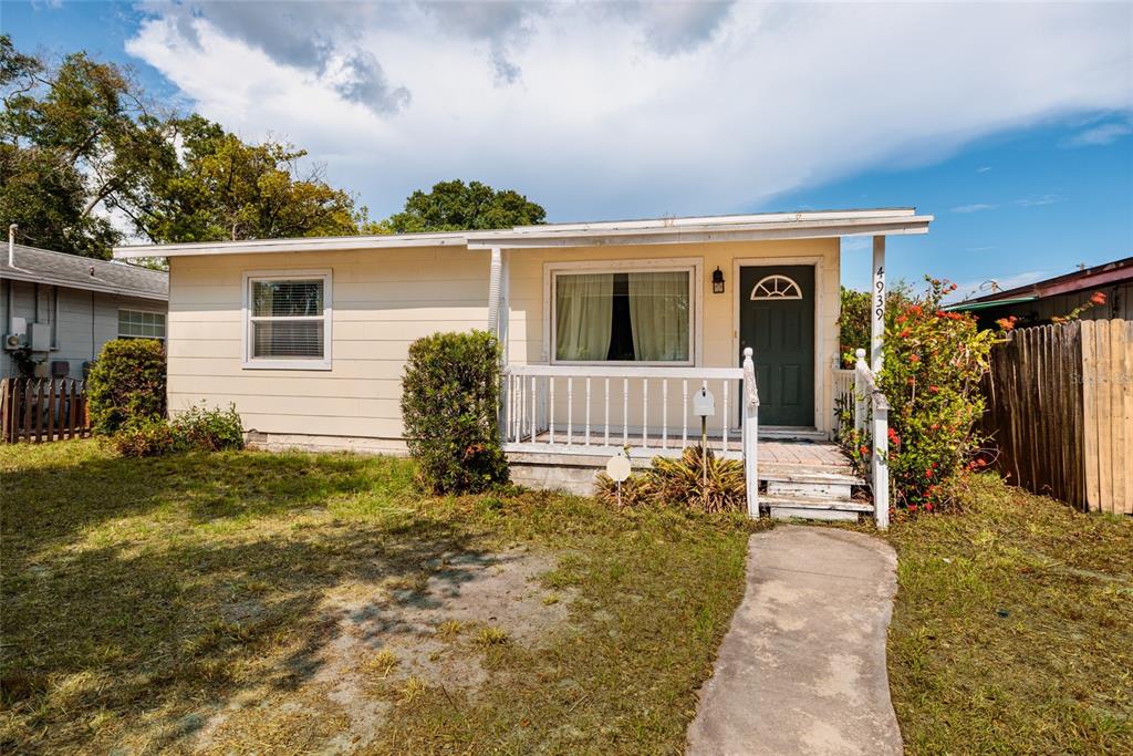 A single-story house with light siding, a front porch, and a concrete walkway — 4939 DR MARTIN LUTHER KING JR STREET N, ST PETERSBURG, FL