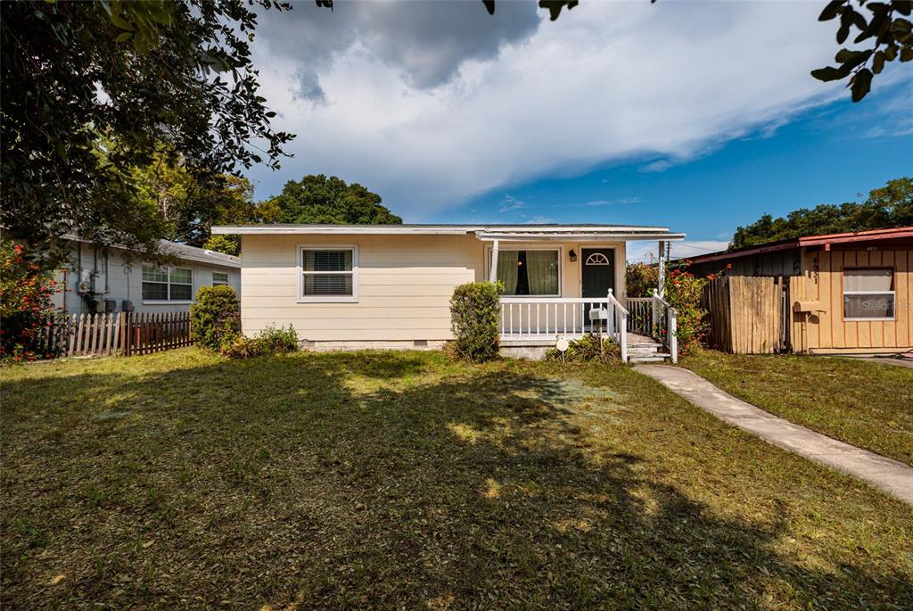 A single-story house with light-colored siding, a front porch, and a grassy yard — 4939 DR MARTIN LUTHER KING JR STREET N, ST PETERSBURG, FL