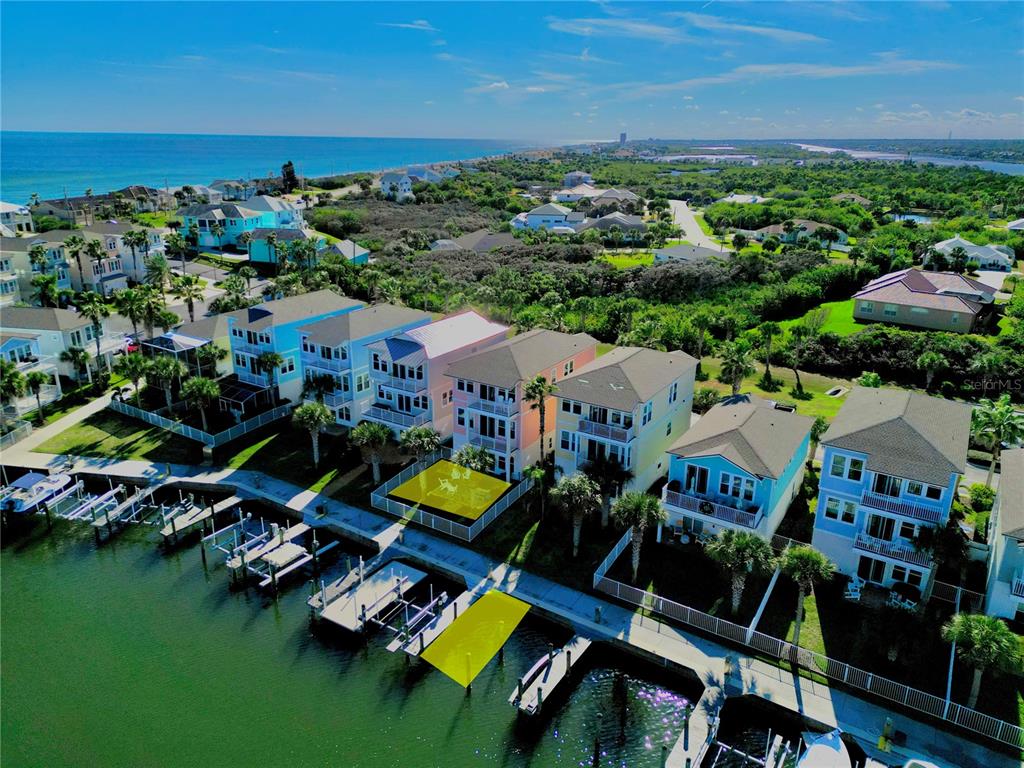 An aerial view shows a row of colorful waterfront houses with private boat docks — 2727 MORNING LIGHT COURT, FLAGLER BEACH, FL
