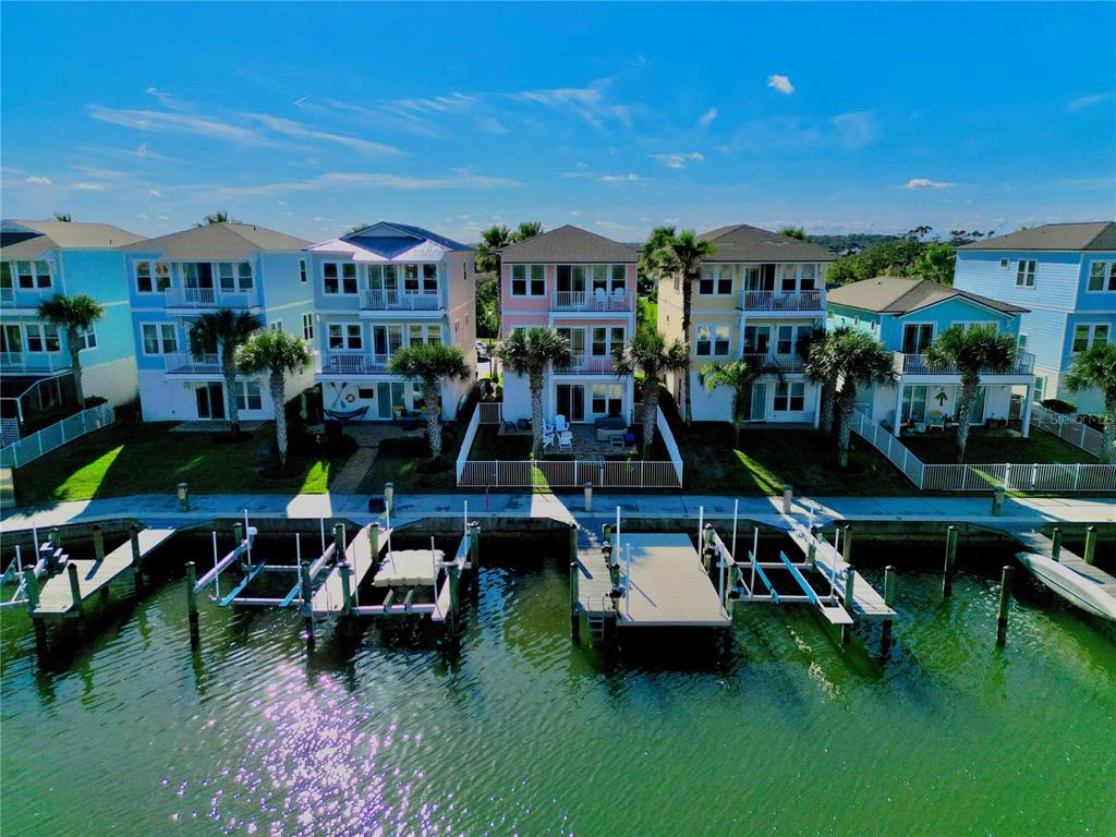 An aerial view shows a row of colorful waterfront houses with private docks and boat lifts — 2727 MORNING LIGHT COURT, FLAGLER BEACH, FL