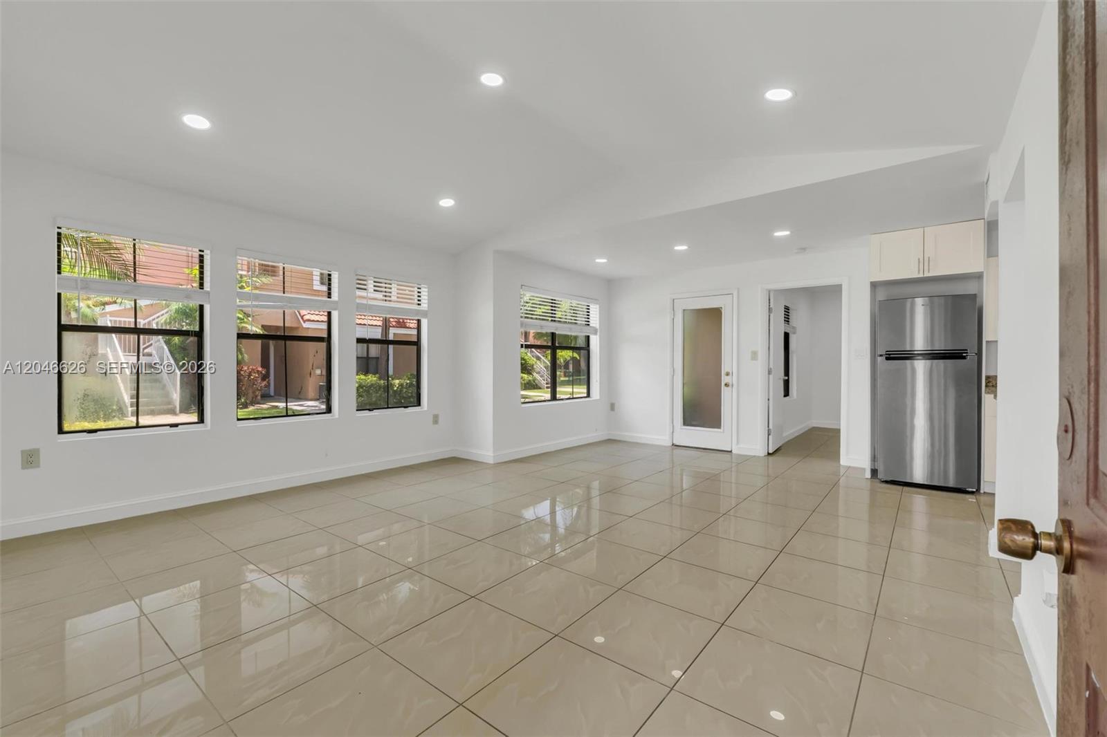 An open-plan living area features white walls, recessed lighting, and large beige floor tiles — 15560 SW 104th Ter # 6112, Miami FL 33196, MIAMI, FL