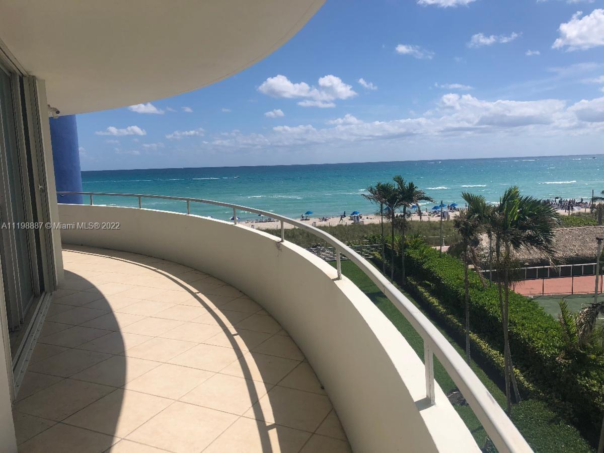 A curved balcony overlooks a sandy beach, ocean, and tennis court — 5151 Collins Ave # 531, Miami Beach FL 33140, MIAMI BEACH, FL