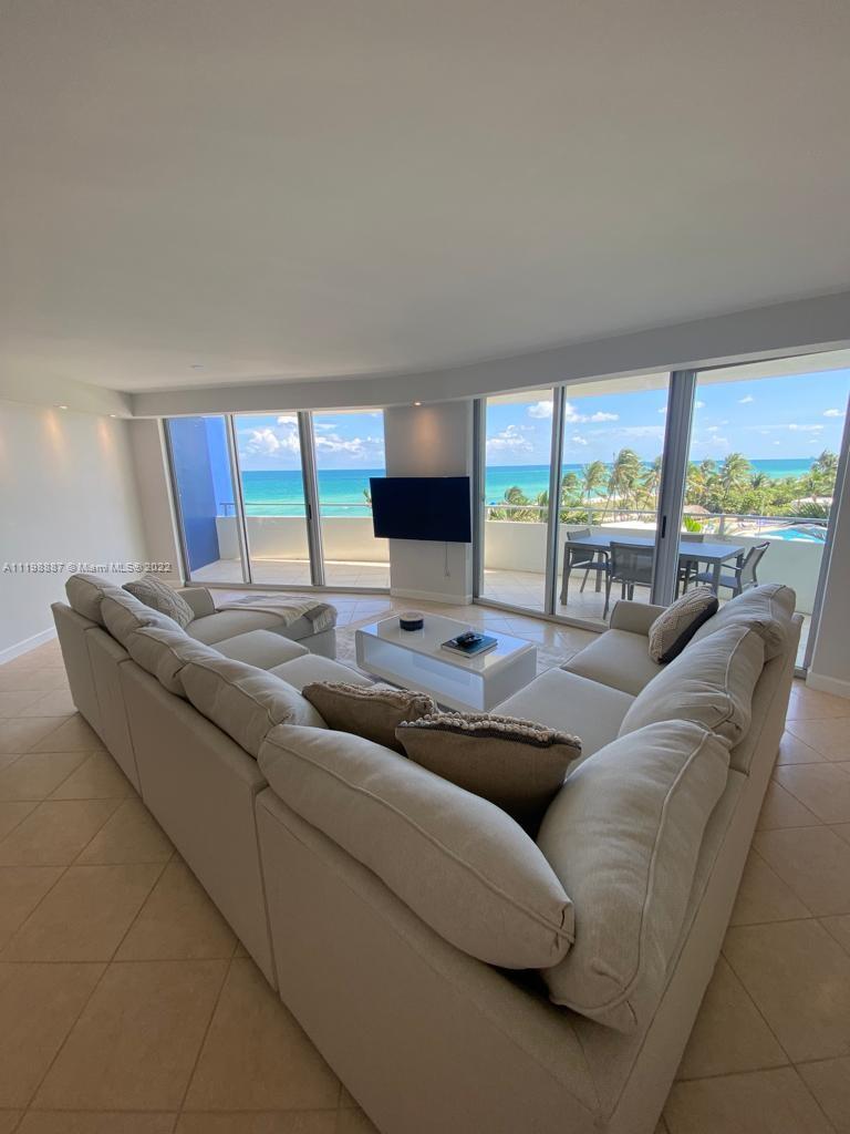 A living room features a large sectional sofa, a white coffee table, and floor-to-ceiling ocean views — 5151 Collins Ave # 531, Miami Beach FL 33140, MIAMI BEACH, FL