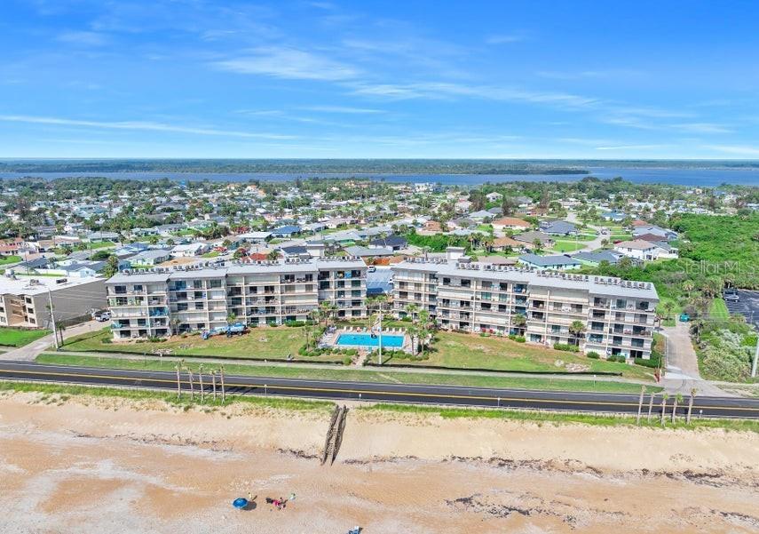 An aerial view of a multi-story beachfront condominium complex with a pool and parking lot — 2700 OCEAN SHORE BOULEVARD UNIT 518, ORMOND BEACH, FL