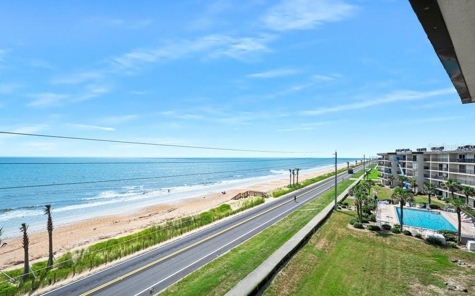 An elevated view of a coastal road, sandy beach, ocean, and a nearby apartment complex — 2700 OCEAN SHORE BOULEVARD UNIT 518, ORMOND BEACH, FL