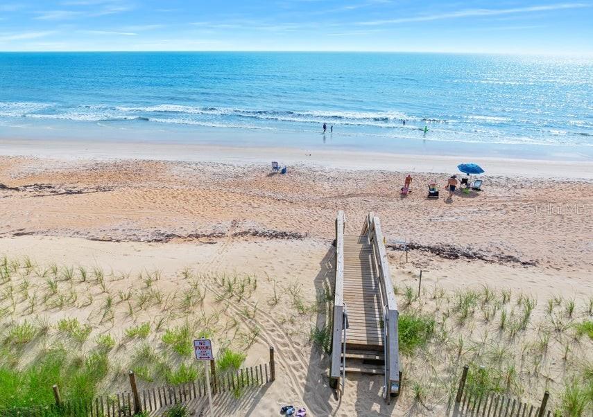 A wooden boardwalk leads from sand dunes down to a sandy beach and the ocean — 2700 OCEAN SHORE BOULEVARD UNIT 518, ORMOND BEACH, FL