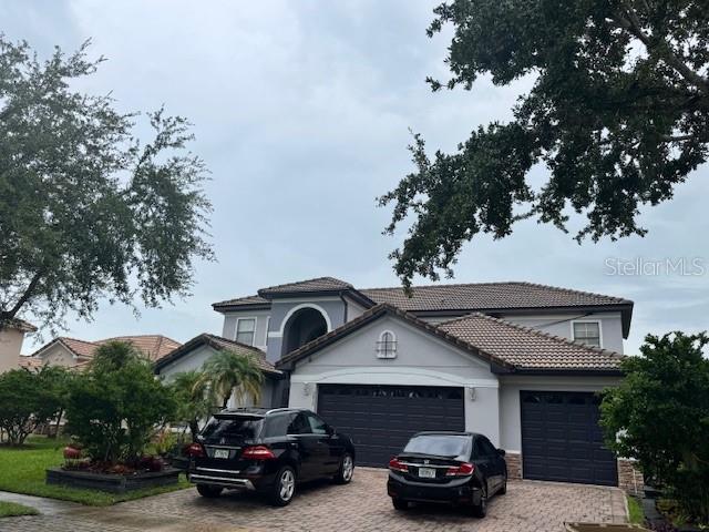 A two-story house with a two-car garage and two parked vehicles in the driveway — 3830 GOLDEN FEATHER WAY, KISSIMMEE, FL