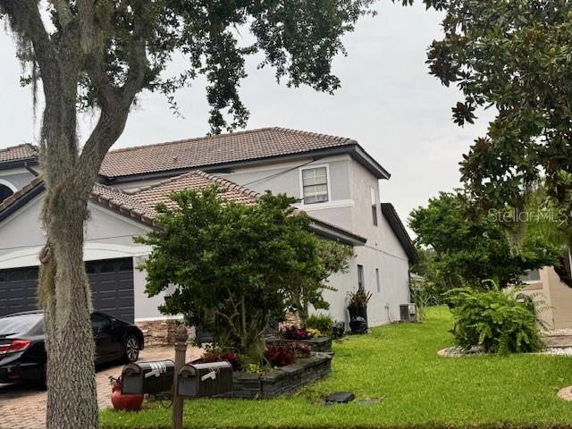 A two-story house with a gray exterior, a tiled roof, and a front yard — 3830 GOLDEN FEATHER WAY, KISSIMMEE, FL
