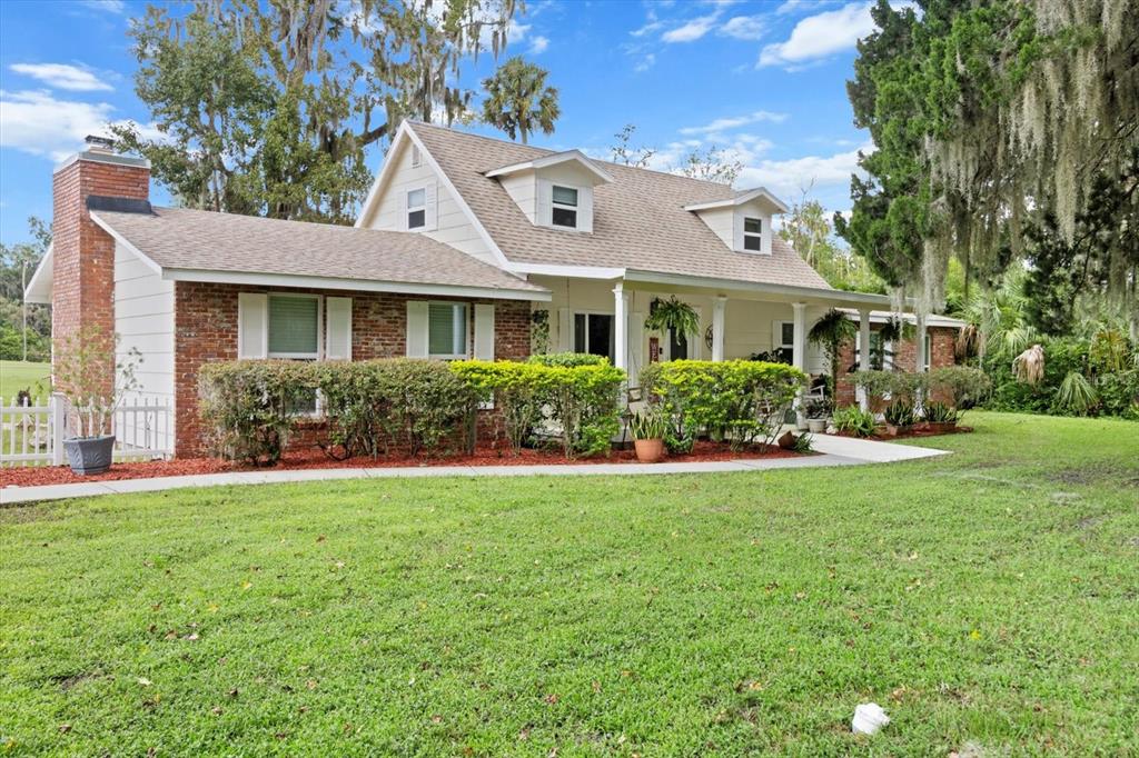 A two-story house with a brick chimney, white siding, and a front porch — 1110 N RICE TERRACE, CRYSTAL RIVER, FL