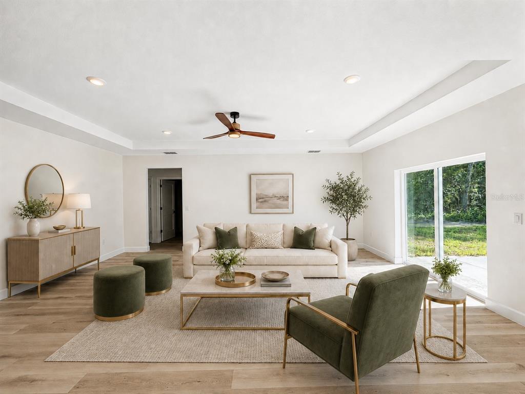 A bright living room features a beige sofa, green accent chairs, and light wood flooring — 4324 SE 135 LANE, SUMMERFIELD, FL
