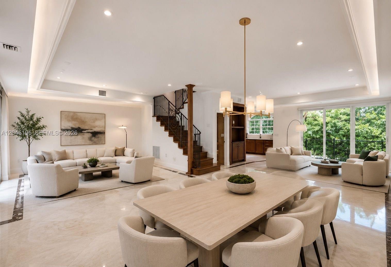 An open-concept living and dining area features marble floors, a wooden staircase, and neutral furniture — 592 Fernwood Rd # B, Key Biscayne FL 33149, KEY BISCAYNE, FL