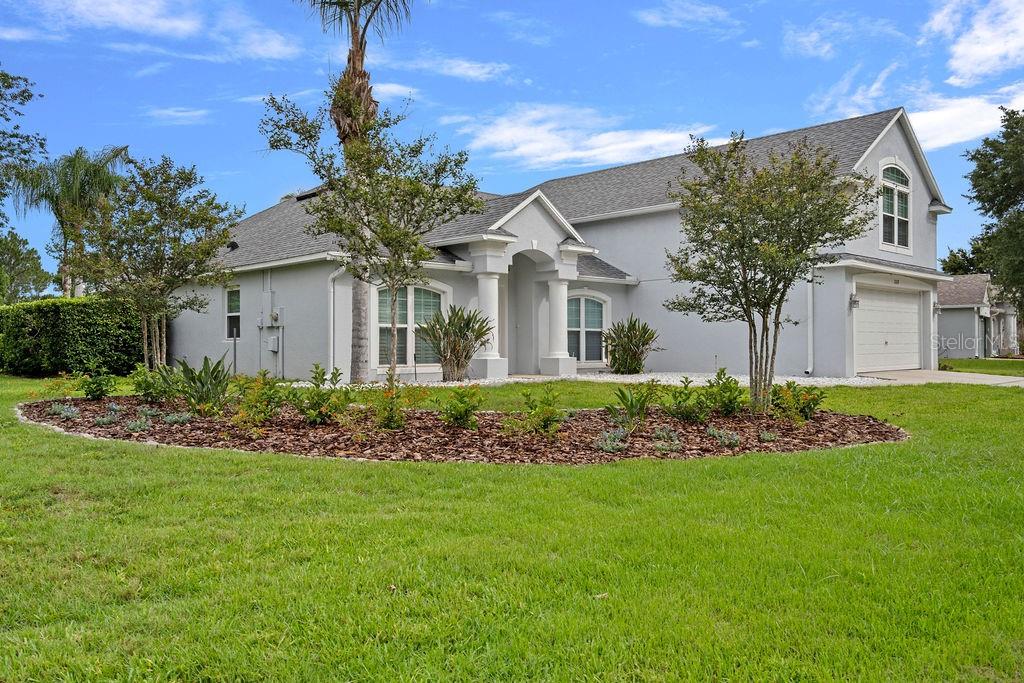 A light gray single-story house with a white-pillared entryway and a two-car garage — 1018 GRAND RESERVE DRIVE, DAVENPORT, FL