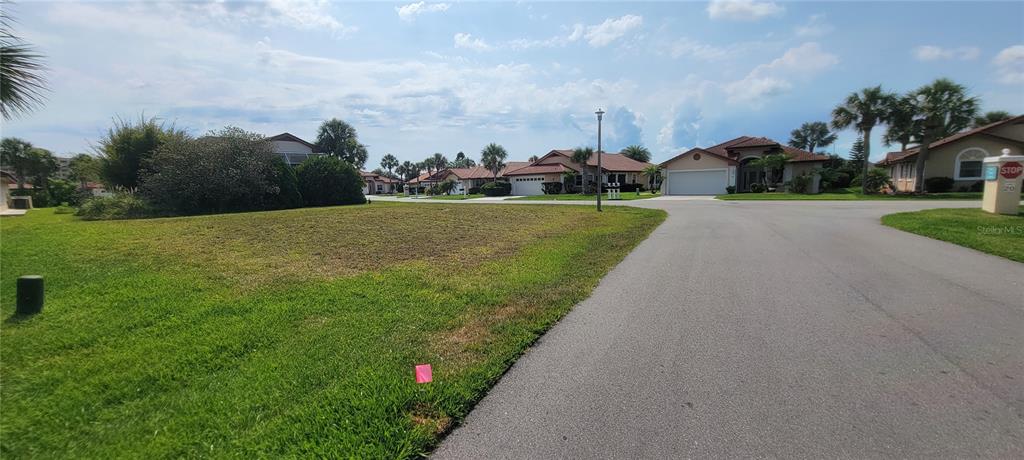 A vacant grassy lot sits next to a paved road in a residential neighborhood — 11 SAN LUIS LANE, PALM COAST, FL