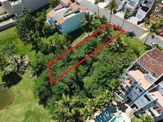An aerial view shows a rectangular vacant lot outlined in red between two residential buildings — 1 MONTECARLO UNIT 149, HUMACAO, PR