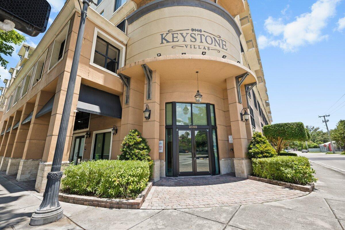 The exterior of a multi-story tan building with a glass entrance and arched signage — 3590 Coral Way # 502, Miami FL 33145, MIAMI, FL