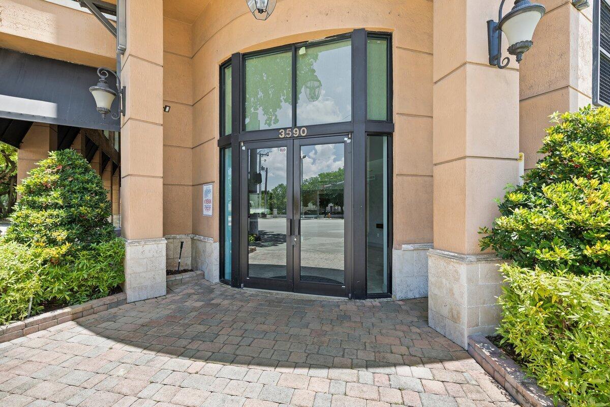 The exterior entrance of a commercial building features glass double doors and stone pavers — 3590 Coral Way # 502, Miami FL 33145, MIAMI, FL