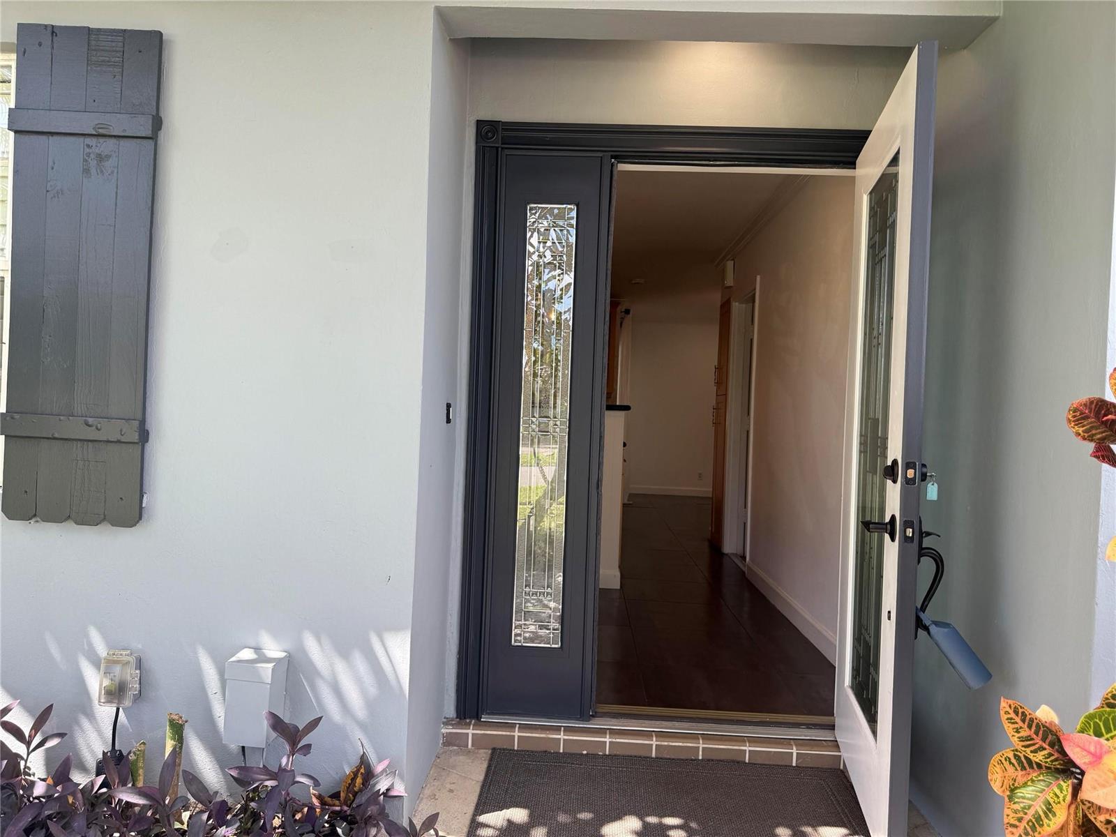 An open front door reveals a tiled entryway leading into the interior of a home — 105 Orchard Ridge Lane, Boca Raton FL 33431, BOCA RATON, FL