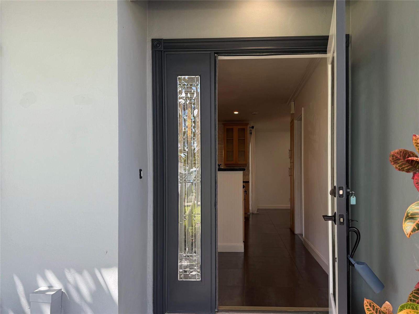 An open dark gray front door with a decorative glass panel reveals an interior hallway — 105 Orchard Ridge Lane, Boca Raton FL 33431, BOCA RATON, FL