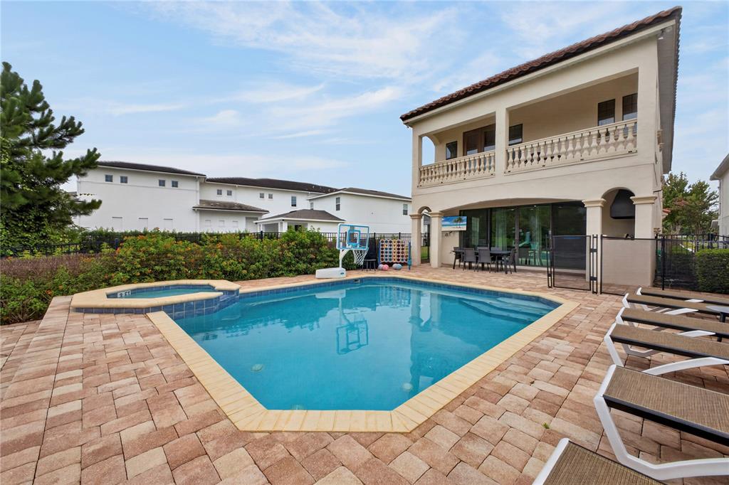 A two-story house features a swimming pool, hot tub, and patio with outdoor furniture — 824 DESERT MOUNTAIN COURT, KISSIMMEE, FL
