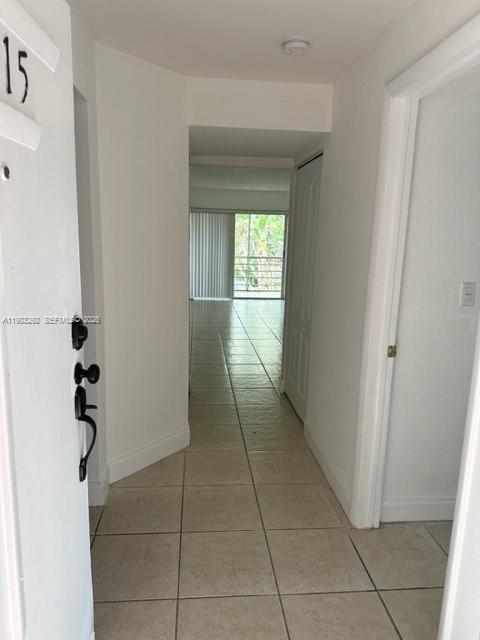 A view from an entryway looking down a tiled hallway toward a windowed living area — 4255 N UNIVERSITY DR # 215, Sunrise FL 33351, SUNRISE, FL