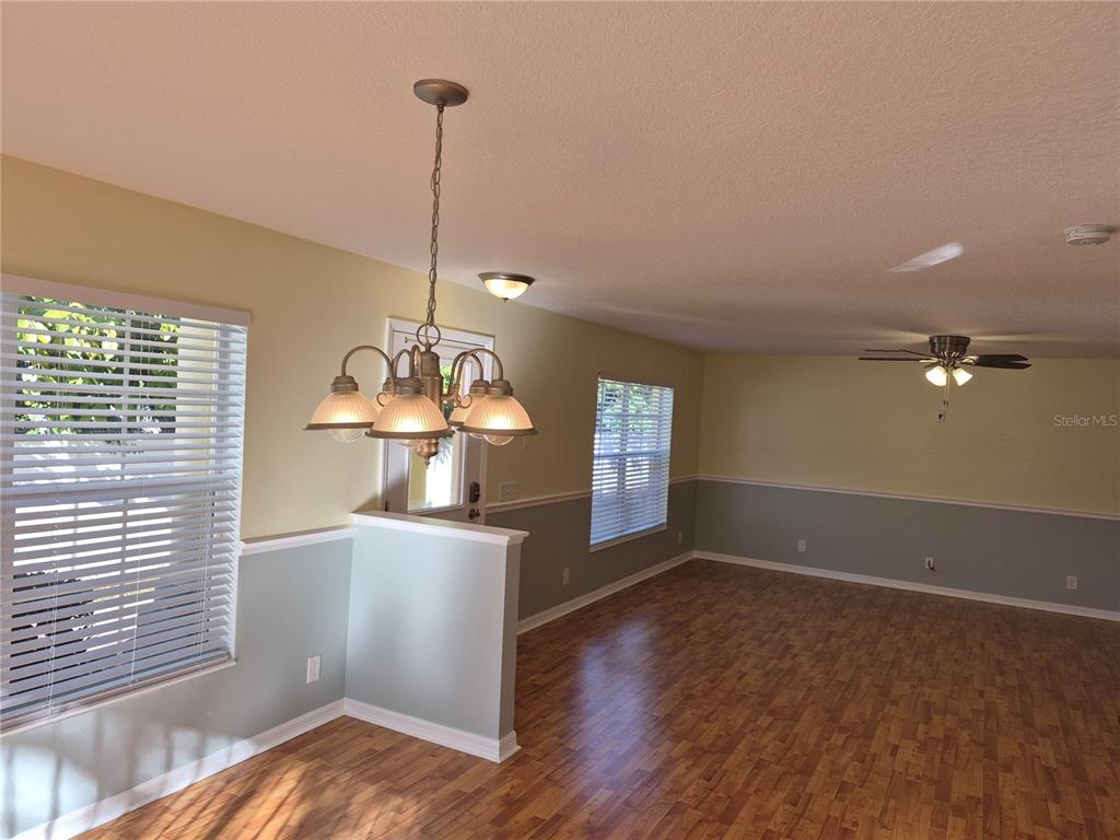 A dining area with a chandelier, wood-look flooring, and two-toned walls with chair rail molding — 3845 ISLAND WAY, ST PETERSBURG, FL