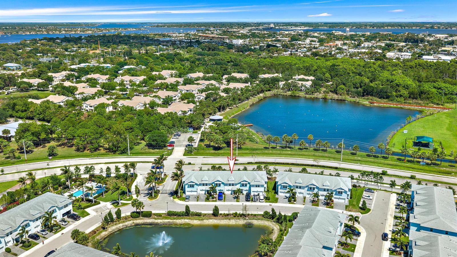 An aerial view shows a multi-unit townhouse building with a red arrow pointing toward it — 327 SE Halifax Lane, Stuart FL 34994, STUART, FL