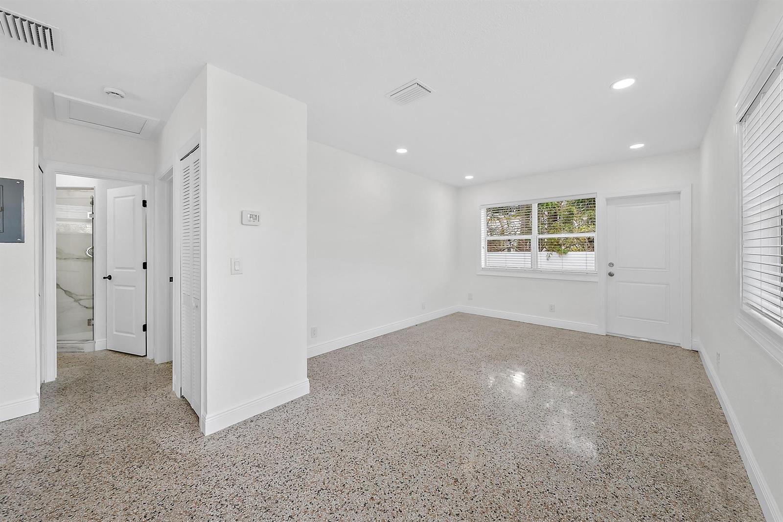 A bright, empty room features white walls, recessed lighting, and speckled terrazzo flooring — 3808 Broadway # 3, West Palm Beach FL 33407, WEST PALM BEACH, FL
