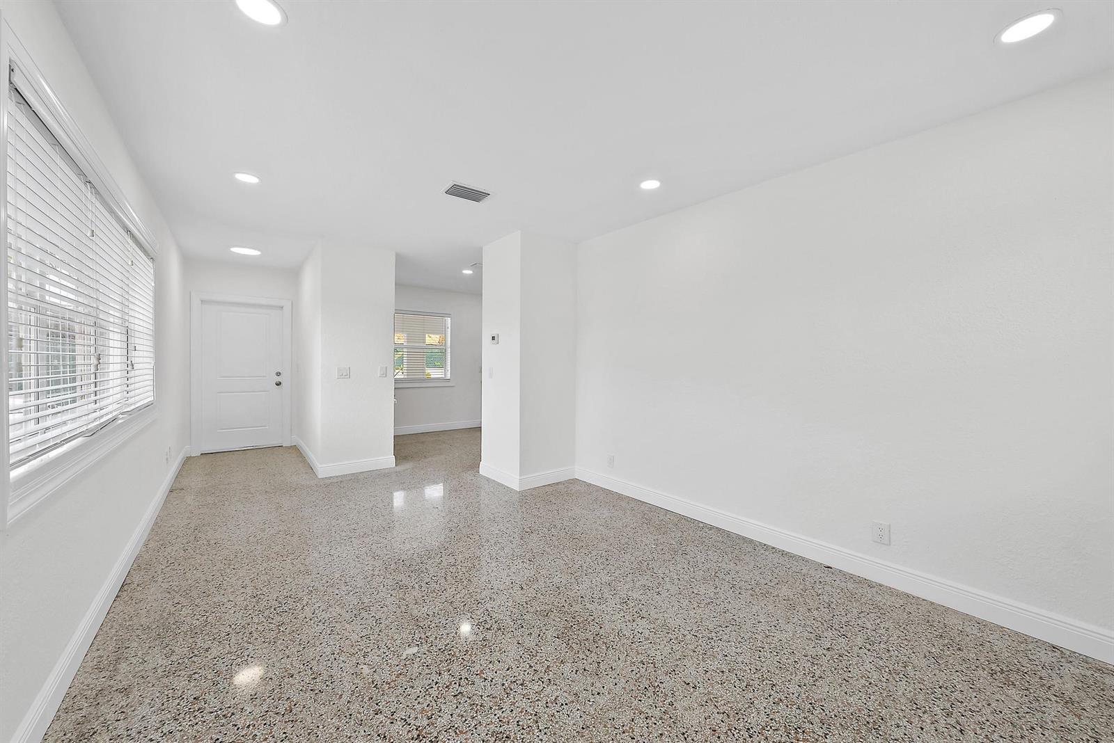 A bright, empty room features white walls, recessed lighting, and a polished terrazzo floor — 3808 Broadway # 3, West Palm Beach FL 33407, WEST PALM BEACH, FL