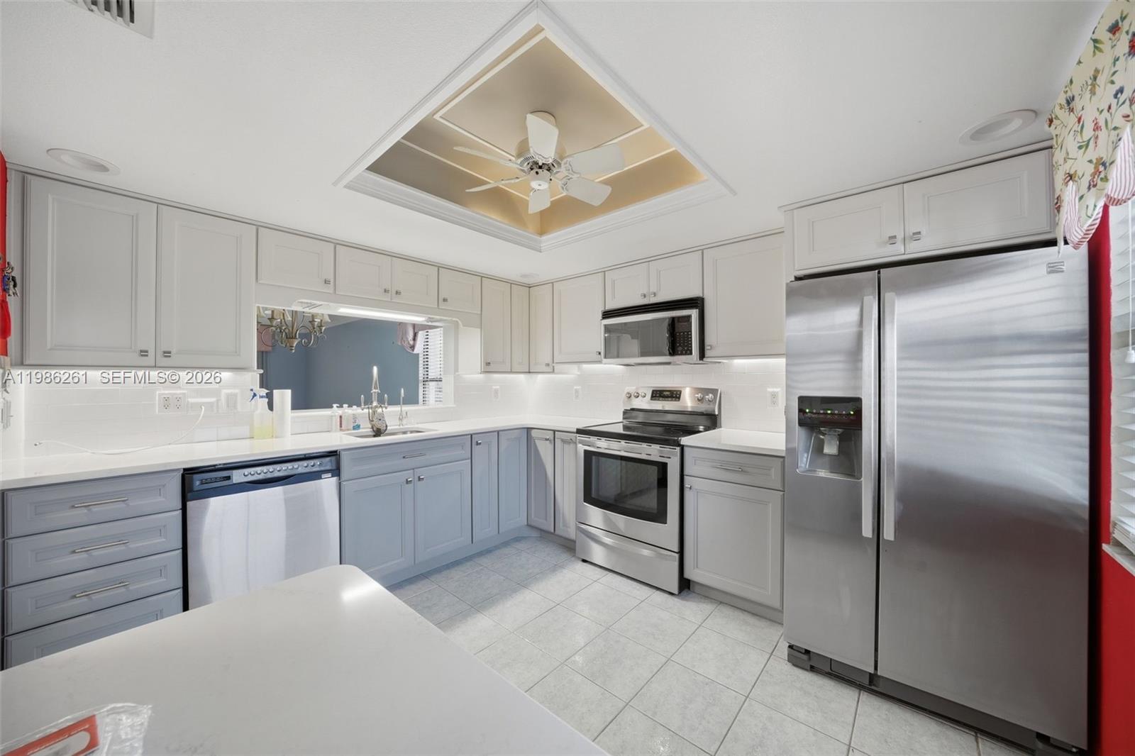 A kitchen features gray cabinets, stainless steel appliances, white countertops, and a recessed ceiling fan — 2130 ELM ST # 401, Clearwater FL 34698, CLEARWATER, FL