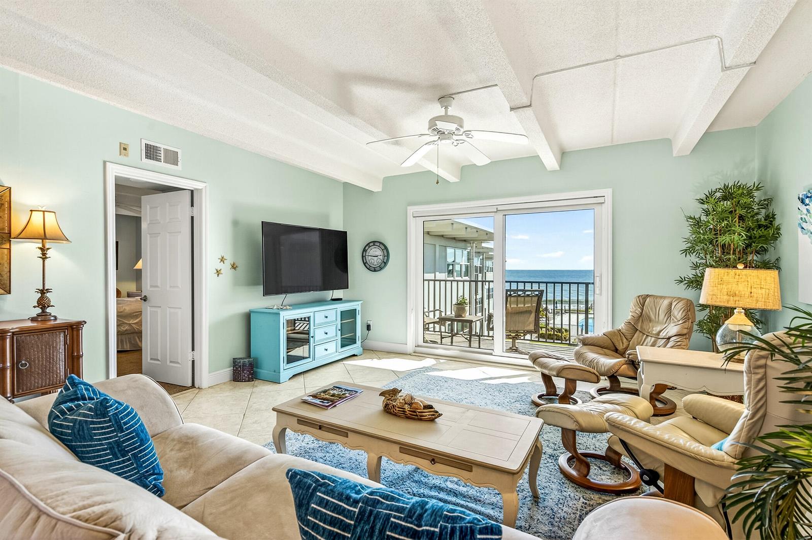 A living room features light blue walls, a beige sofa, two recliners, and a balcony view — 4410 Highway A1a # 307, Vero Beach FL 32963, VERO BEACH, FL