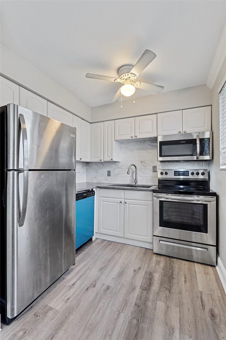 A kitchen with white cabinets, stainless steel appliances, a blue dishwasher, and wood-look flooring — 2130 NE 42nd Court # 4, Lighthouse Point FL 33064, LIGHTHOUSE POINT, FL