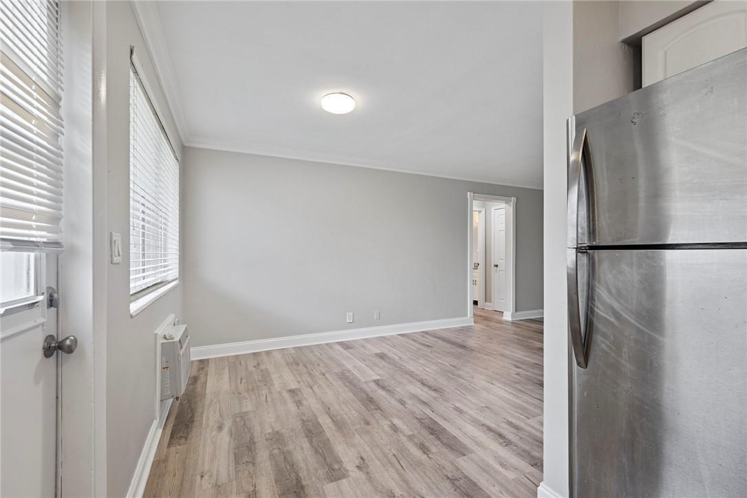 A view of a room with wood-look flooring, a window, and a stainless steel refrigerator — 2130 NE 42nd Court # 4, Lighthouse Point FL 33064, LIGHTHOUSE POINT, FL