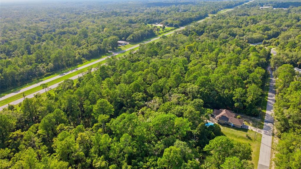 An aerial view shows a house with a pool surrounded by dense forest and roads — 5995 N BROOKGREEN DRIVE, CRYSTAL RIVER, FL