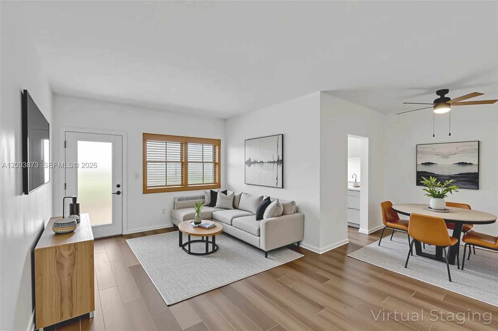 This virtually staged living and dining area features white walls, wood-look flooring, and modern furniture — 1334 Euclid Ave # 8, Miami Beach FL 33139, MIAMI BEACH, FL