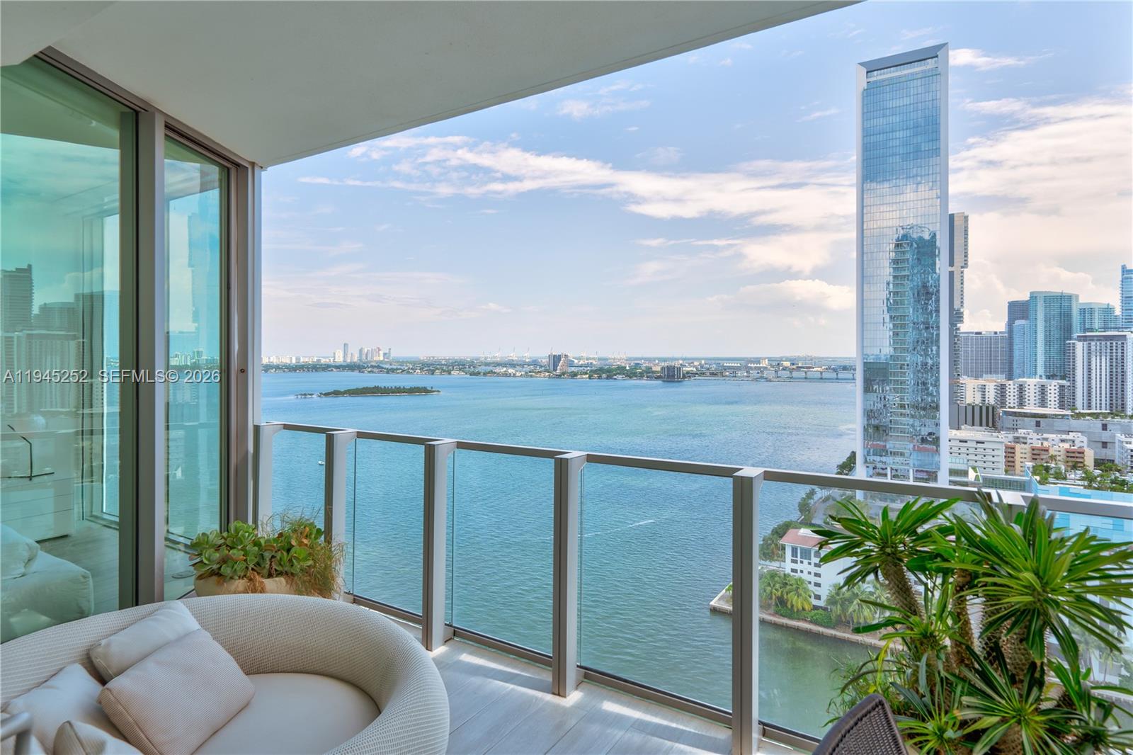 A balcony with a glass railing overlooks a bay and a city skyline — 2900 NE 7th Ave # 2309, Miami FL 33137, MIAMI, FL